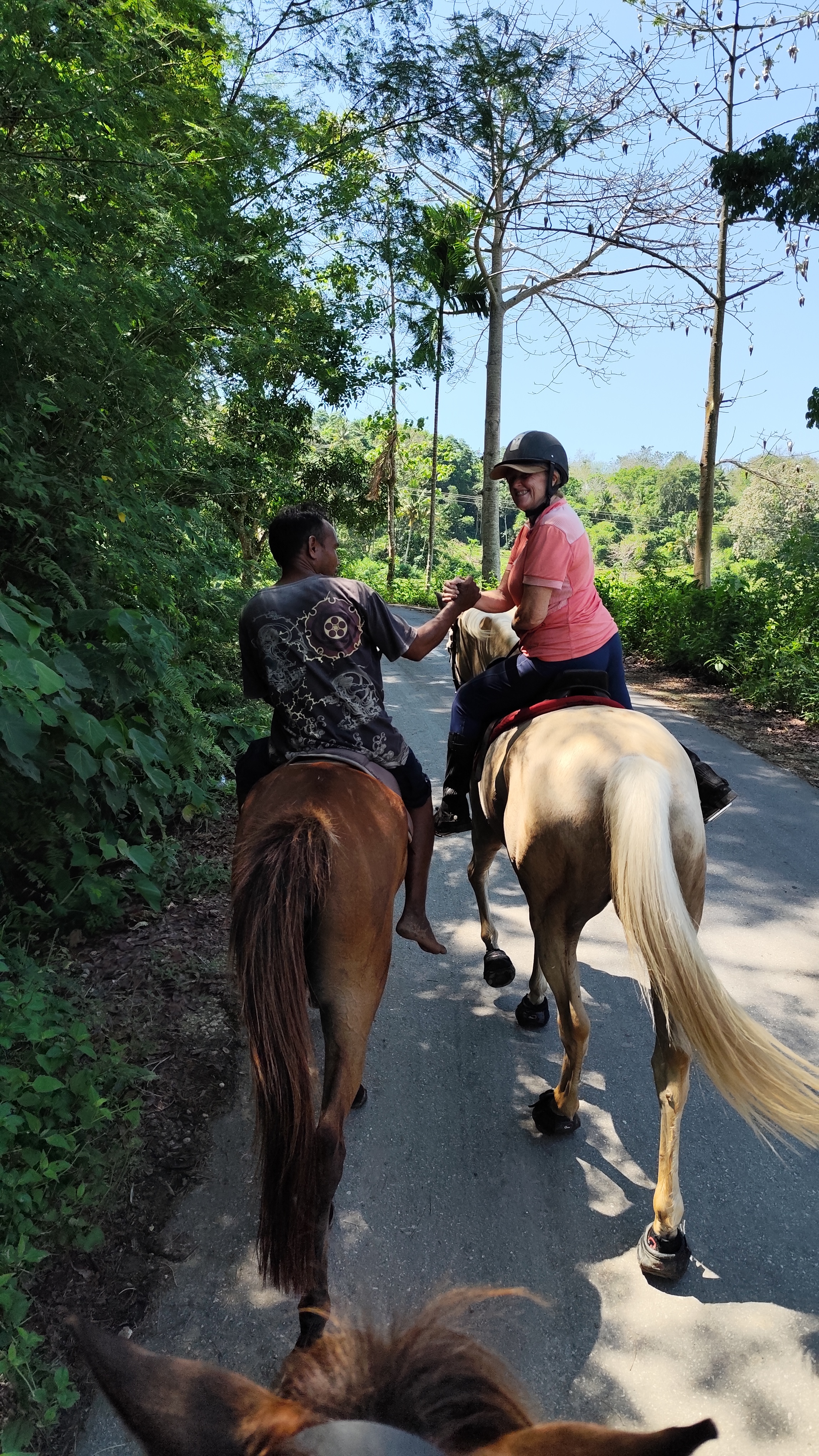 Two riders sharing a handshake on a forest trail